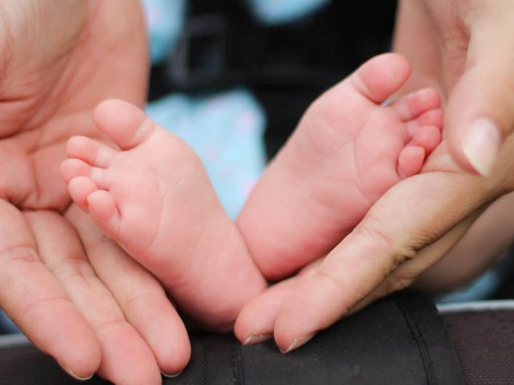 pies de bebé y manos de adulto