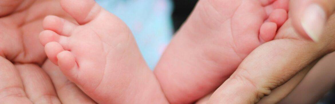 pies de bebé y manos de adulto